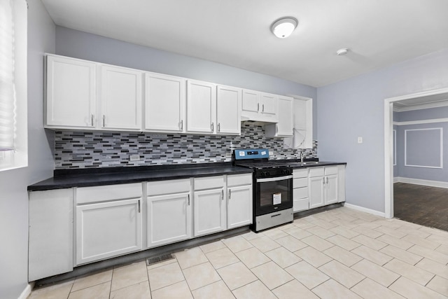 8025 S Evans Ave, Chicago, IL 60619 - kitchen with tasteful backsplash, dark countertops, stainless steel range with gas stovetop, and white cabinets