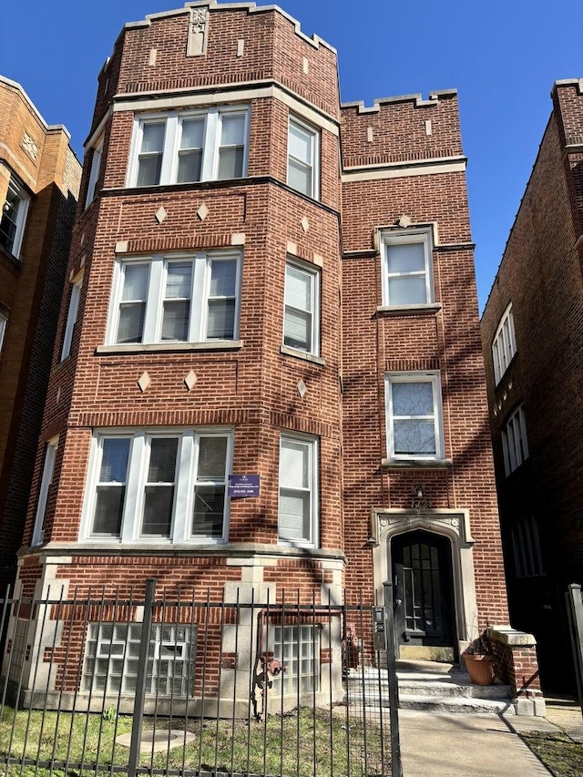 view of front of house featuring brick siding and a fenced front yard