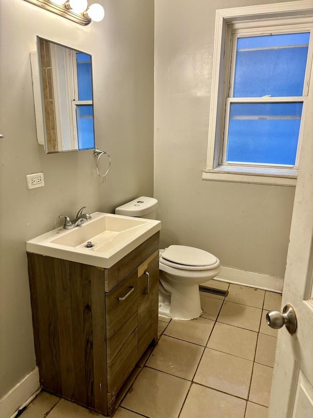 half bath featuring baseboards, toilet, tile patterned floors, and vanity