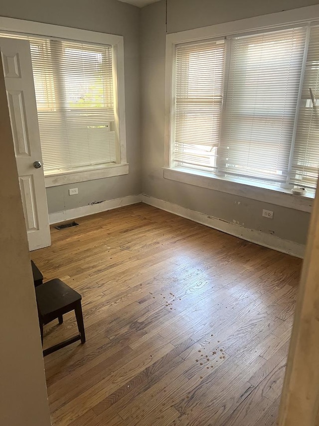 spare room featuring hardwood / wood-style floors and baseboards