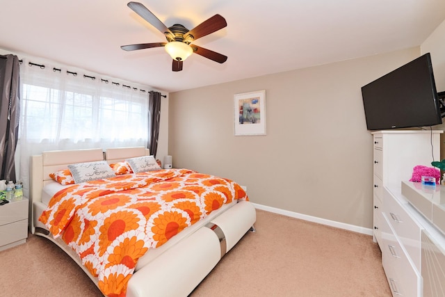 bedroom featuring baseboards, light carpet, and ceiling fan