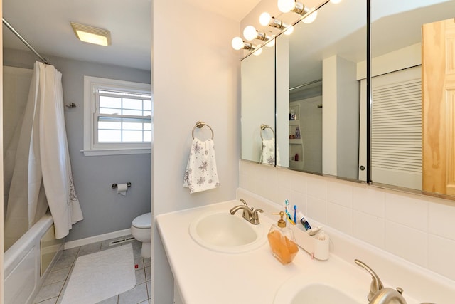 bathroom featuring a sink, backsplash, toilet, and tile patterned flooring