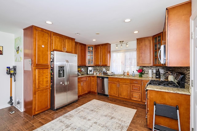 kitchen with brown cabinets, dark wood-style flooring, and stainless steel appliances