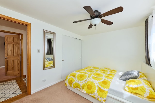 carpeted bedroom with baseboards, a closet, and ceiling fan