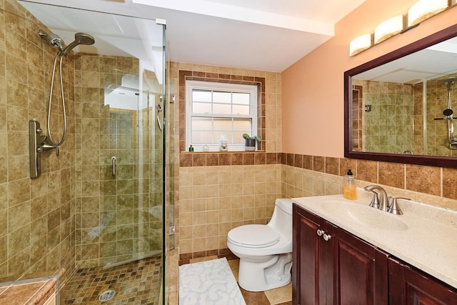 bathroom with vanity, toilet, tile walls, and a shower stall