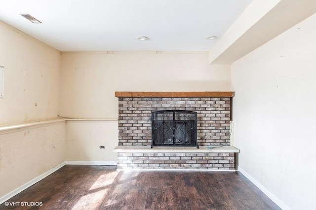 unfurnished living room with a fireplace, wood finished floors, visible vents, and baseboards