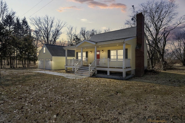 view of front of property with an outbuilding, a porch, and a chimney