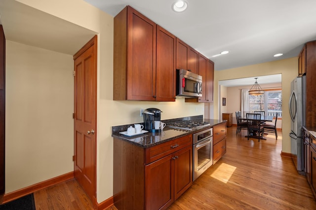 kitchen featuring recessed lighting, light wood-type flooring, baseboards, and appliances with stainless steel finishes