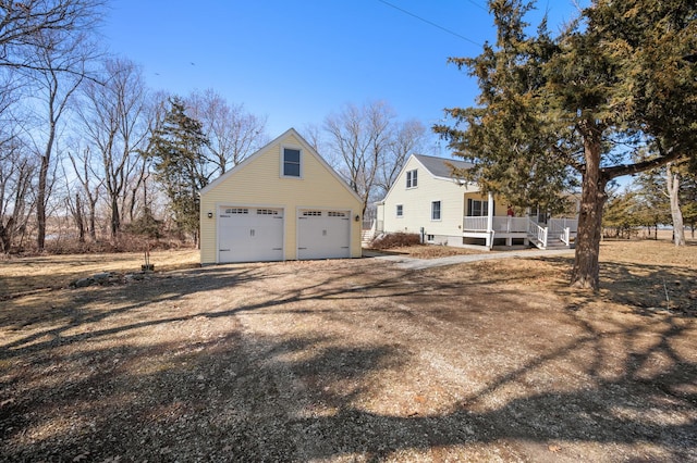 exterior space featuring a garage, covered porch, and an outdoor structure