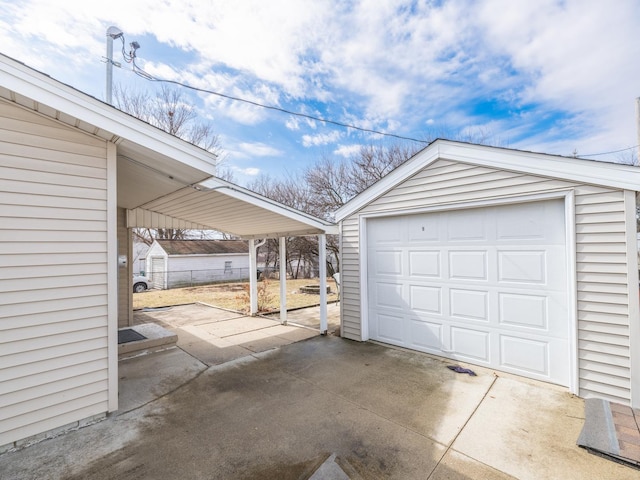 detached garage featuring driveway and fence