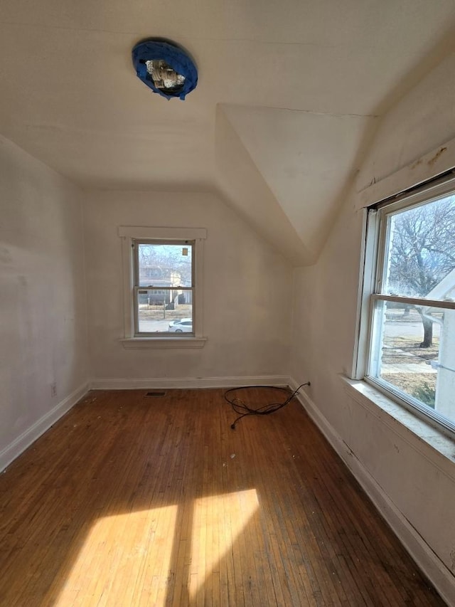 bonus room featuring baseboards, lofted ceiling, plenty of natural light, and hardwood / wood-style flooring