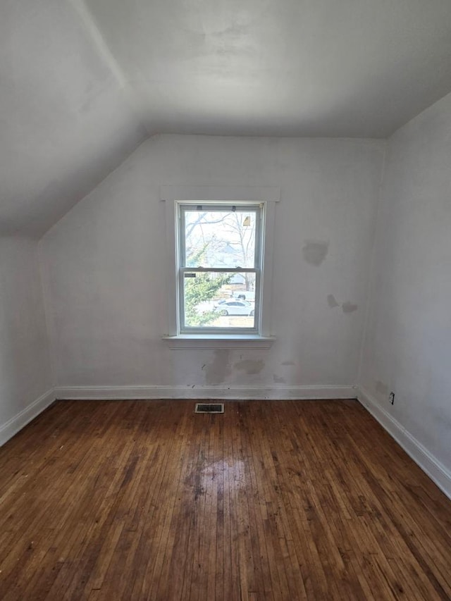 bonus room with hardwood / wood-style floors, vaulted ceiling, baseboards, and visible vents