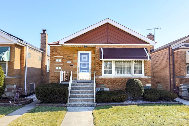 view of front facade with a front lawn, brick siding, and a chimney