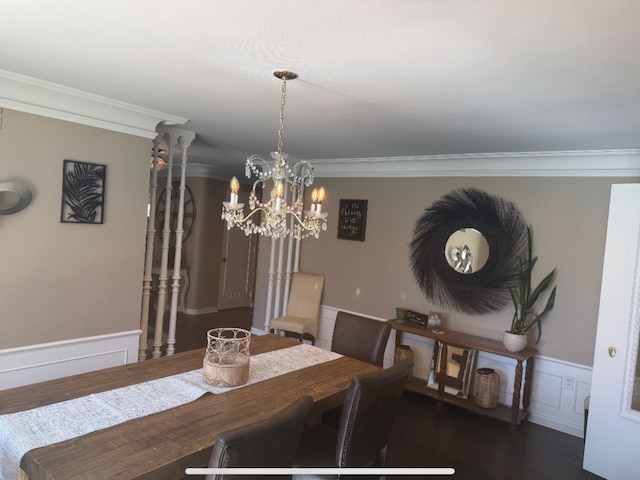 dining room with a decorative wall, crown molding, a wainscoted wall, wood finished floors, and a notable chandelier