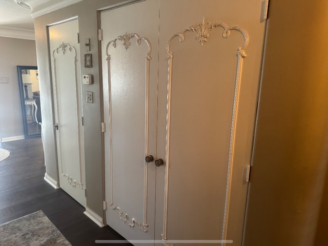 hallway featuring baseboards, dark wood-style floors, and crown molding