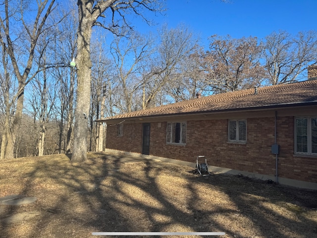 exterior space with brick siding and a chimney