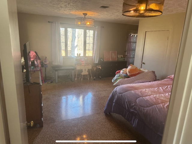 bedroom with speckled floor, visible vents, and a textured ceiling