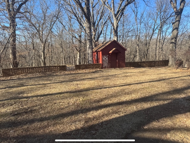 view of yard with an outdoor structure and a forest view