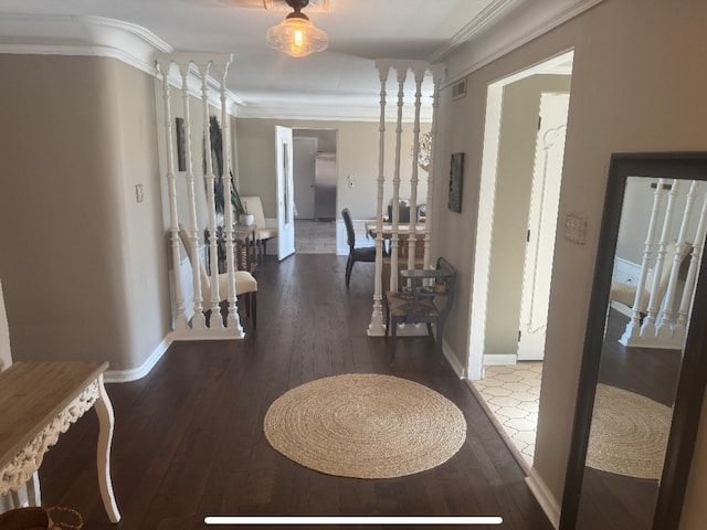 hall featuring visible vents, hardwood / wood-style floors, baseboards, and ornamental molding