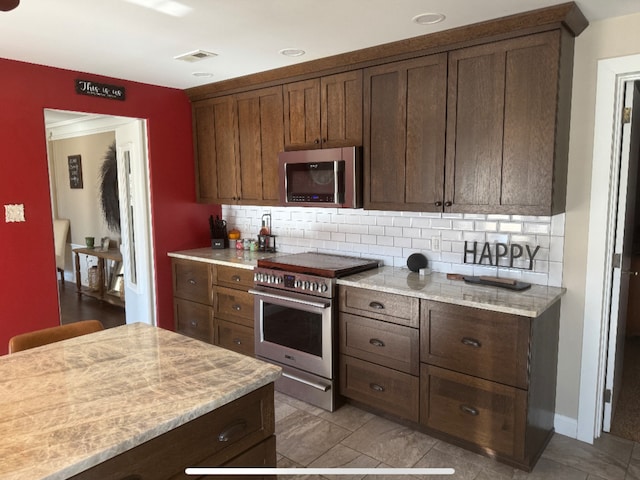 kitchen featuring visible vents, baseboards, backsplash, and appliances with stainless steel finishes