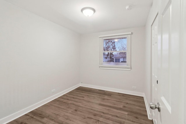 unfurnished room featuring visible vents, baseboards, and wood finished floors