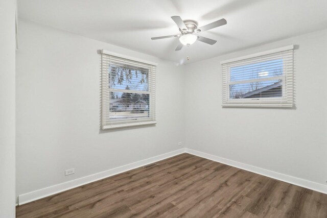 unfurnished bedroom with a closet, baseboards, and dark wood-type flooring