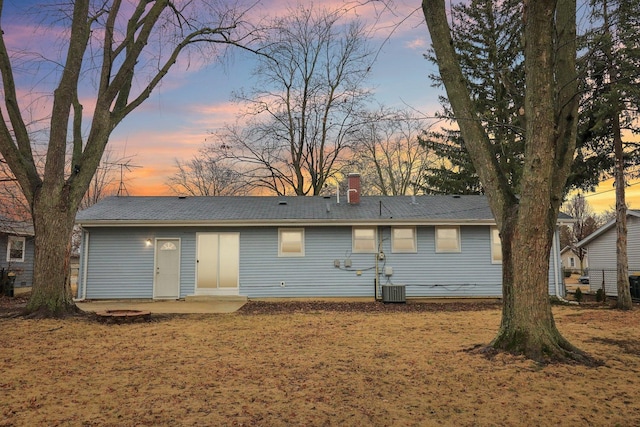 rear view of house with cooling unit and a chimney