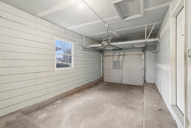 garage with wooden walls and a garage door opener