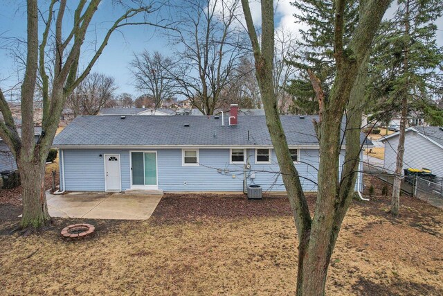 rear view of property with a chimney, a patio area, cooling unit, and a shingled roof