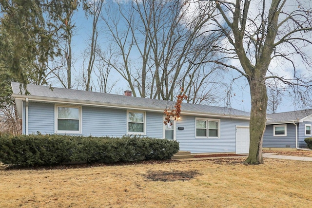 single story home with a garage, a front yard, and a chimney