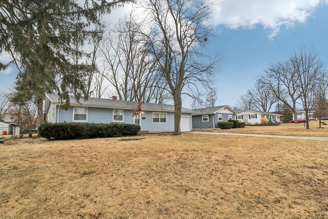 ranch-style home featuring a front lawn, an attached garage, and a chimney