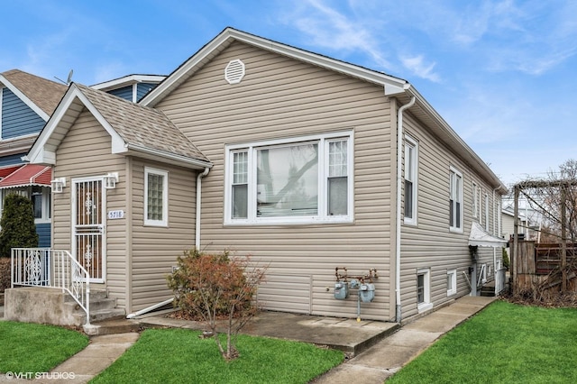 view of front of house with a shingled roof and a front yard