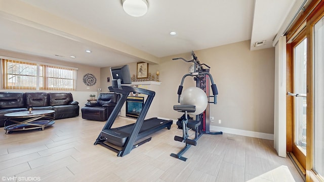 exercise room featuring recessed lighting, baseboards, and a fireplace