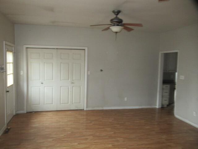 unfurnished bedroom with a closet, baseboards, light wood-style floors, and a ceiling fan