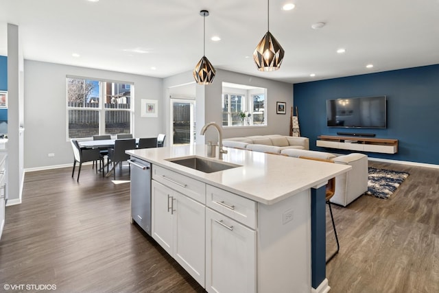 kitchen with a sink, dark wood-type flooring, open floor plan, white cabinetry, and stainless steel dishwasher