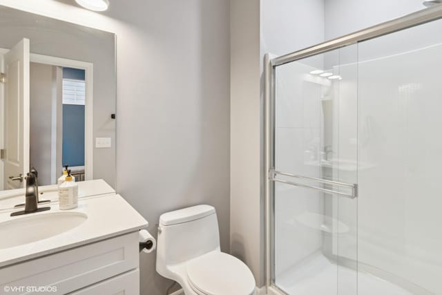 bathroom with vanity, toilet, and a shower stall