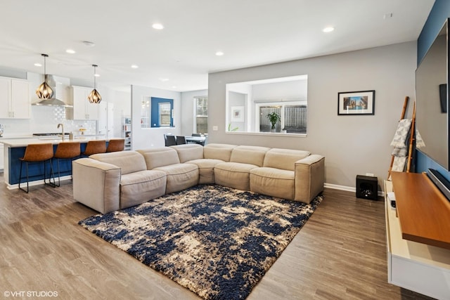 living area featuring recessed lighting, light wood-type flooring, and baseboards