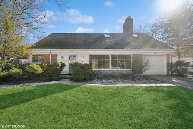 view of front of property featuring driveway, a front yard, an attached garage, brick siding, and a chimney