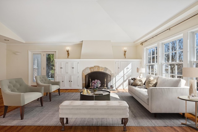 living room featuring a premium fireplace, high vaulted ceiling, and wood finished floors