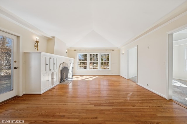 unfurnished living room featuring light wood-type flooring, a fireplace with flush hearth, baseboards, and vaulted ceiling