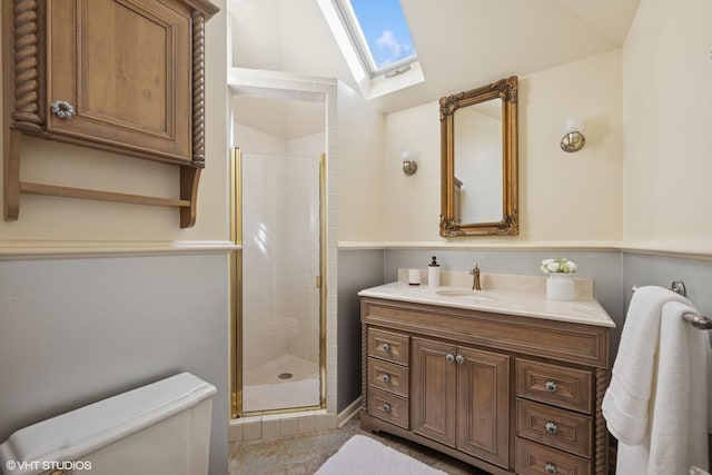 bathroom featuring vaulted ceiling with skylight, vanity, toilet, and a shower stall