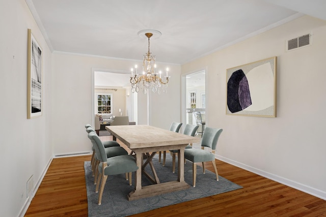 dining area featuring visible vents, baseboards, wood finished floors, and ornamental molding