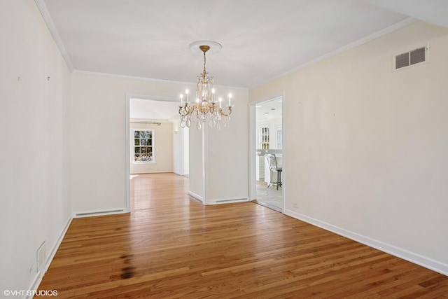 unfurnished dining area with visible vents, baseboards, wood finished floors, and crown molding