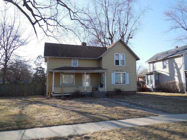 traditional-style house with a chimney and fence