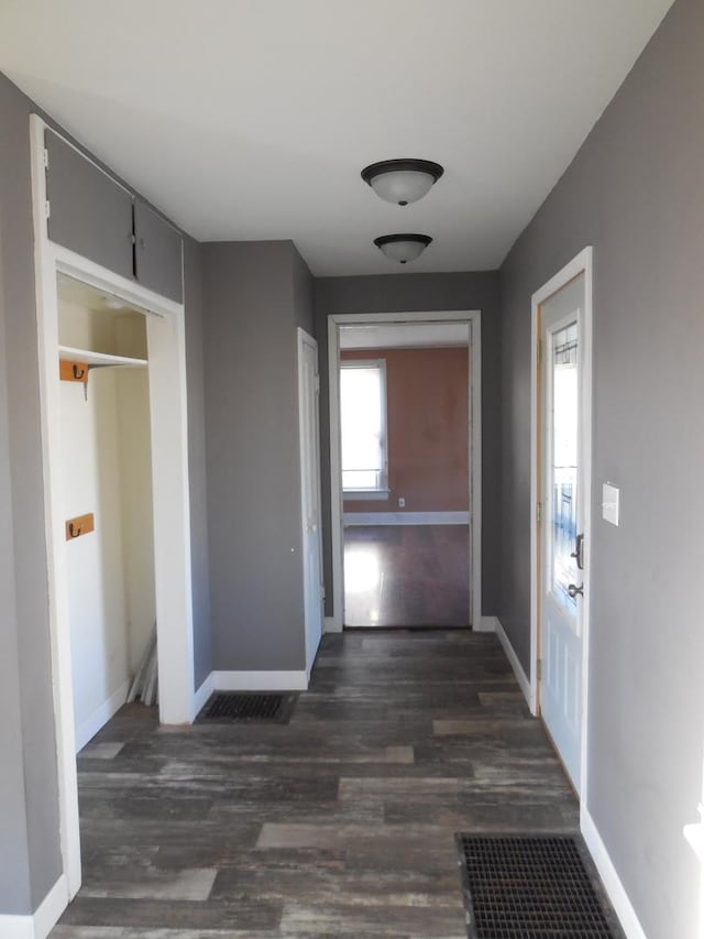 hallway with baseboards and dark wood-style floors