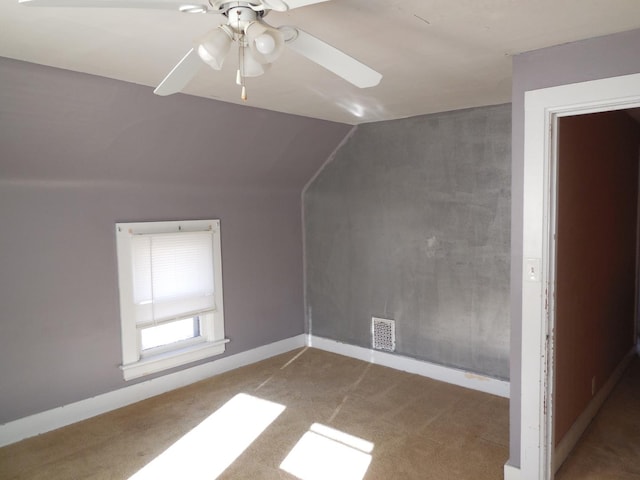 additional living space featuring vaulted ceiling, carpet flooring, baseboards, and visible vents