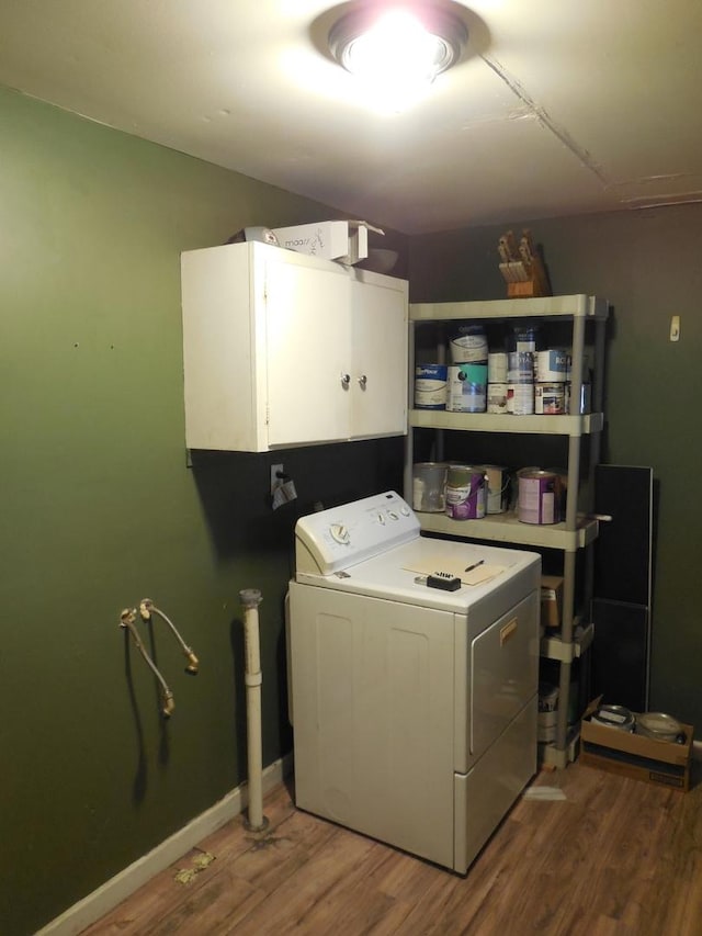 laundry area featuring washer / dryer, wood finished floors, cabinet space, and baseboards