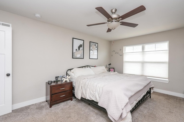 bedroom with visible vents, light colored carpet, baseboards, and ceiling fan