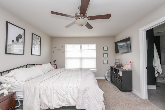 bedroom featuring light colored carpet, a ceiling fan, and baseboards