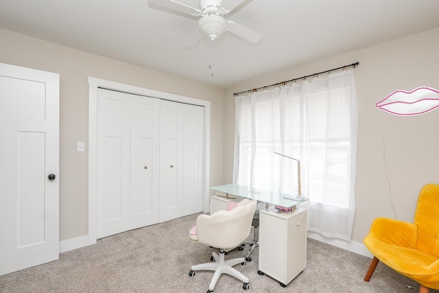 office space featuring light carpet, baseboards, and a ceiling fan